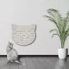 kleine rote Katze sitzt vor einem weißen Katzenkopf der an der Wand hängt